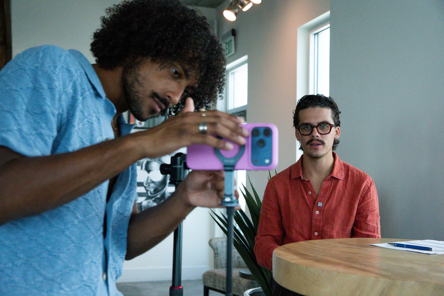 Nelson Rivera setting up a phone rig on a tripod before filming a talking-head video